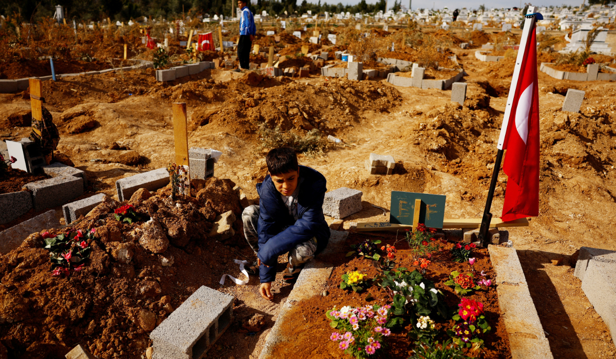 صالح دوغرو ، 12 عامًا ، وابن عمه إرين دوغرو ، 14 عامًا ، يزورون قبور ضحايا الزلزال في مقبرة جانكايا ، حيث انتقلوا إليها في أعقاب زلزال 6 فبراير الذي ضرب سوريا وتركيا.  (أ ف ب)