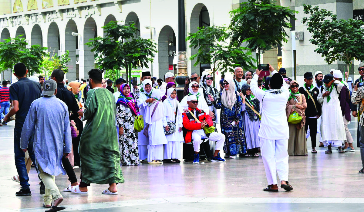 A group of traditionally dressed umrah visitors whose presence in Makkah and Madinah coincided with Eid Al-Fitr are seen taking a photo to commemorate the day. (SPA)