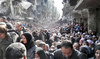 Residents of the besieged Palestinian camp of Yarmouk, lining up to receive food supplies, in Damascus, Syria. (AP)