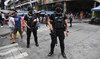 Members of police Special Weapons and Tactics (SWAT) stand guard along a popular market street in Manila on June 1, 2022. (AFP)
