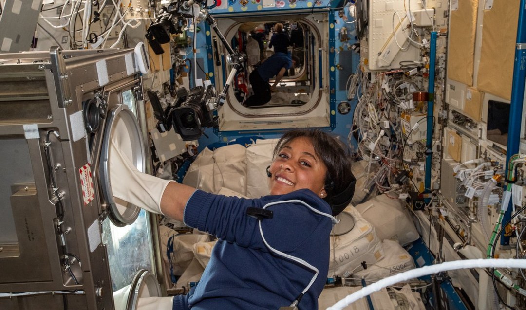 Saudi astronaut Rayyanah Barnawi uses the live science gloves box to conduct experiments on human immune cells.