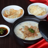 Congee or chinese rice porridge with dori fish, cakwe, chips and fish sauce