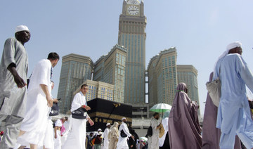 The tallest clock tower in the world with the world's largest clock face, atop the Abraj Al-Bait Towers, overshadows Muslim pilgrims at the Grand Mosque, in Makkah, Saudi Arabia, Aug. 5, 2019. (AP)