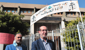 Hezbollah legal representative Ibrahim Mussawi, right, walks outside the Justice Ministry as he arrives to speak with journalists in Beirut, Lebanon, Friday. (AP)