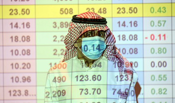 A Saudi trader wears a mask as he monitors stock information at the Saudi stock market in Riyadh, Saudi Arabia. (Reuters/File)