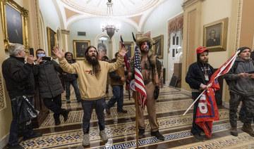 In this Jan. 6, 2021 file photo, supporters of President Donald Trump are confronted by US Capitol Police officers outside the Senate Chamber inside the Capitol in Washington. On Jan. 8, 2021, The Associated Press reported on stories circulating online incorrectly asserting that Capitol rioters were antifa activists. At center is Jake Angeli, wearing fur hat with horns, a regular at pro-Trump events and a known follower of QAnon. (AP Photo/Manuel Balce Ceneta)