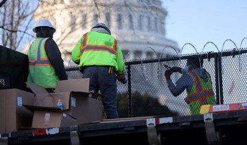 Workers install razor wire atop the unscalable fence surrounding the US Capitol in the wake of the January 6th riot and ahead of the upcoming inauguration in Washington on January 14, 2021. (REUTERS/Jonathan Ernst)