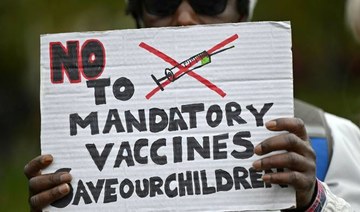 A protester holds up a placard at a demonstration in London in October against mandatory vaccinations. A leading Muslim scholar in Canada warned people not to believe conspiracy theories about the coronavirus vaccine. (AFP/File Photo)