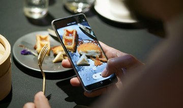 A guest uses a mobile phone to take a video of a meal featuring a nugget made from lab-grown chicken meat during a media presentation in Singapore, the first country to allow the sale of meat created without slaughtering any animals, on December 22, 2020. (AFP/File Photo)