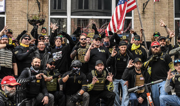 Members of the Proud Boys pose for a photo while flashing a gesture associated with the white power movement outside of Harry's bar during a protest on December 12, 2020 in Washington, DC (AFP)