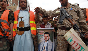 A fighter stands guard before a portrait of Hussein Badreddin Al-Houthi, the founder of Ansar Allah (aka the Houthi movement), during a rally in Sanaa on Sept. 14, 2020. (AFP/File Photo)