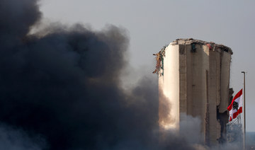 The Lebanese flag flies next to the Beirut port silo, damaged in the August 4 explosion, as smoke billows from a huge fire there on September 10, 2020. (AFP/File Photo)