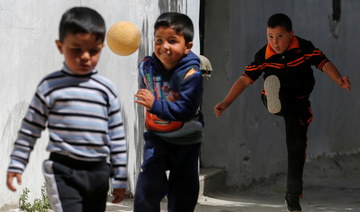 Palestinian boys play football at Dheisheh refugee camp, near Bethlehem in the Israeli-occupied West Bank April 8, 2021. (Reuters)