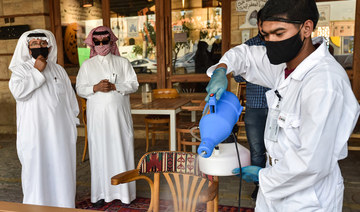 A worker sanitises a table for clients at a cafe in Saudi Arabia's capital Riyadh on June 21, 2020, as the country begins to re-open following the lifting of a COVID-19 lockdown. (AFP/File Photo)