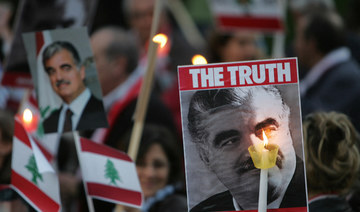 Pictures of slain former Lebanese premier Rafiq Hariri, national flags and lighting candles are seen during a demonstration held by some 200 lebanese protesters in downtown Athens. (AFP/File Photo)