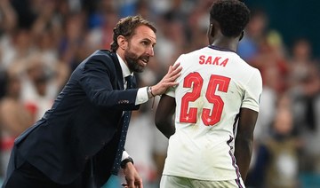 England's coach Gareth Southgate (L) speaks with England's midfielder Bukayo Saka during the UEFA EURO 2020 final football match. (AFP)