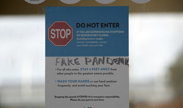 A sign about stopping the spread of COVID-19, the words "fake pandemic" written on it, is posted at Los Angeles International Airport (LAX) during the outbreak of the novel coronavirus. (File/AFP)