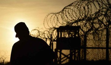 An US soldier walking next to the razor wire-topped fence at the abandoned "Camp X-Ray" detention facility at the US Naval Station in Guantanamo Bay, Cuba, April 9, 2014. (AFP)