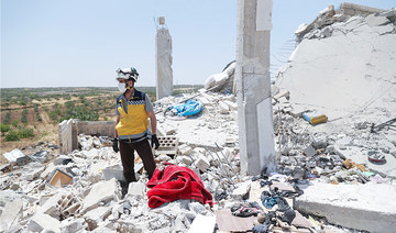 A member of the Syrian Civil Defense (White Helmets) services salvages items from the rubble of a damaged house following regime shelling in Jabal Al-Zawiya’s Balyun village, in the south of Syria’s Idlib. (File/AFP)
