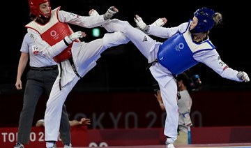 Britain's Jade Jones and Refugee Olympic Team's Kimia Alizadeh Zenoorin (Red) compete in the taekwondo women's -57kg elimination round bout during the Tokyo 2020 Olympic Games. (AFP)