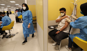 An Iranian health worker inoculates a man at a COVOD-19 vaccination center set up inside the Iran Mall in Tehran on August 14, 2021.(Photo by ATTA KENARE / AFP)