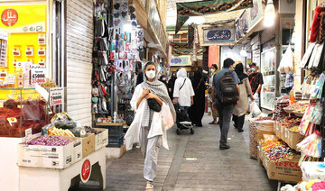 Mask-clad people shop at the Tajrish Bazaar market in Tehran on Sunday. Iran tightened curbs to contain the spread of the coronavirus. (AFP)