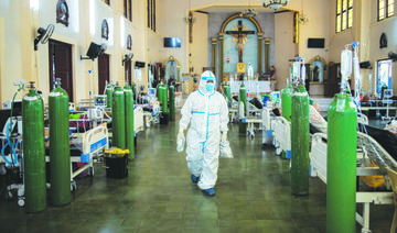A health worker walks around to check on coronavirus disease patients admitted in the chapel of Quezon City General Hospital turned into a COVID-19 ward, in Quezon City, Philippines, August 20, 2021. (REUTERS)