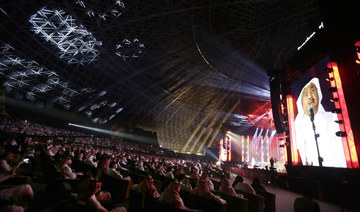 Audience cheer as Saudi prominent singer Mohammed Abdu, on the screen, performs at the newly built Super Dome, in Jeddah, Saudi Arabia. (AP file photo)