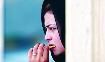 An Afghan woman eats a biscuit in Kabul on Saturday. The UN report said the Taliban’s takeover of the country has put 20 years of ‘steady economic gains at risk.’ (AFP)