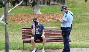 A police officer interacts with a man at Sydney Park on September 18, 2021, following calls for an anti-lockdown protest rally amid the coronavirus pandemic. (AFP)