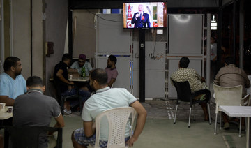Tunisians sit in a cybercafe in Tunis, on September 20, 2021 as they watch television and listen to Tunisia's President Kais Saied delivering a speech. (File/AFP)