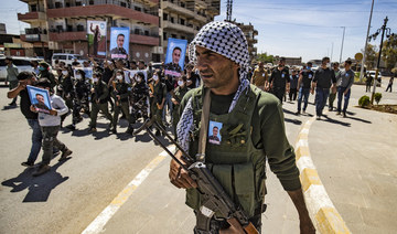 Members of the Syrian Kurdish internal security services known as “Asayish” march in a procession ahead of the body of their fallen comrade Khalid Hajji. (AFP/File Photo)
