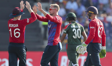 England's captain Eoin Morgan, left, congratulates teammate Liam Livingstone after taking the wicket of Bangladesh's captain Mohammad Mahmudullah during the Cricket Twenty20 World Cup match between England and Bangladesh in Abu Dhabi. (AP)