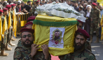 Hezbollah fighters brandish weapons at the funeral procession (above) of a slain comrade, with experts predicting that the group will resist calls to disarm. (AFP/File Photo)