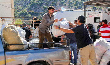 Syrian refugees load their belongings onto a vehicle as they prepare to be evacuated from the southern Lebanese village of Shebaa on July 28, 2018, to return back to Syria. (AFP)