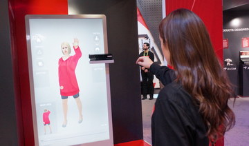 An employee of Chinese tech giant JD.com shows an augmented reality system that allows customers to virtually try on clothing at shops. (AFP/File Photo)