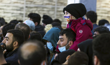 Migrants from Iraq lineup to be registered on a special flight to Iraq at the National Airport outside Minsk, Belarus, Thursday, Nov. 18, 2021. (BelTA via AP)