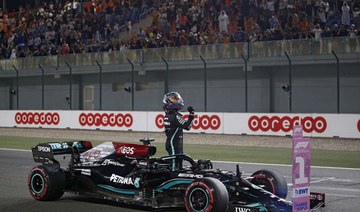 Mercedes' British driver Lewis Hamilton celebrates after the qualifying session ahead of the Qatari Formula One Grand Prix at the Losail International Circuit. (AFP)