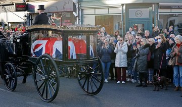 Crowds line the road as a horse-drawn hearse carrying the casket passes Iveagh Hall, David Amess's constituency office during a procession through the streets after the funeral service for the Conservative MP. (AFP)