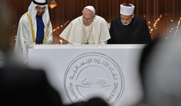 Abu Dhabi’s Crown Prince Mohammed bin Zayed al-Nahyan (L) watches as Pope Francis (C) and Egypt’s Azhar Grand Imam Sheikh Ahmed Al-Tayeb sign documents during the Human Fraternity Meeting in 2019. (AFP/File Photo)