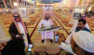 Visitors take photos of a musician playing an Arabic traditional instrument at Souq Al Ahsa World Heritage UNESCO Village. (REUTERS file photo)