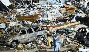 People embrace as tornado damage is seen after extreme weather hit the region December 12, 2021, in Mayfield, Kentucky. (AFP)