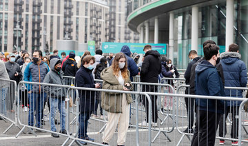 Members of the public queue outside the newly-set up Wembley Stadium vaccination centre to receive their the Covid-19 vaccine or booster at a mass vaccination event in London on December 19, 2021. (AFP)