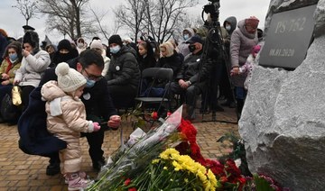 A man lays flowers during a commemorative ceremony for those on Ukraine International Airlines Flight 752, shot down in Iran. (AFP)