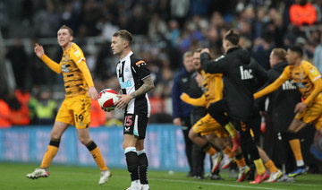 Cambridge United players celebrate as Newcastle United's Kieran Trippier looks dejected after the match. (Reuters)