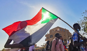 A Sudanese man carries a national flag during a protest against the October 2021 military coup, in the capital Khartoum, on January 9, 2022. (AFP)