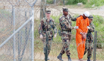 In this Feb. 6, 2002, file photo a detainee is led by military police to be interrogated by military officials at Camp X-Ray at the U.S. Naval Base at Guantanamo Bay, Cuba. (AP)
