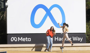 Facebook employees take a photo with the company's new name and logo outside its headquarters in Menlo Park, Calif., Oct. 28, 2021. (AP)