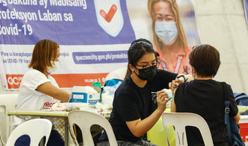 A resident receives a BioNtech Pfizer Covid-19 jab as a booster, at a vaccination center in Quezon city on January 27, 2022, amidst rising covid-19 infections in the capital driven by Omicron variant. (AFP)