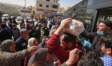 People queue to buy subsidised bread from a municipal bus in the Marka suburb in the east of Jordan's capital Amman. (AFP/File Photo)